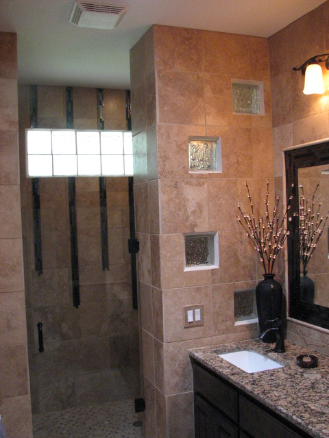 A bathroom remodel showing a walk in shower accented by a glass block design and fine cabinetry.