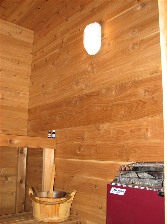 A Custom Dry Sauna Room With Natural Cedar Benches and Walls